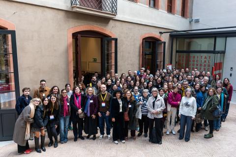 Un centenar d'assistents de la jornada al pati del Hub Social Barcelona. Tots miren a càmera, la foto ha estat presa des d'un lloc elevat.